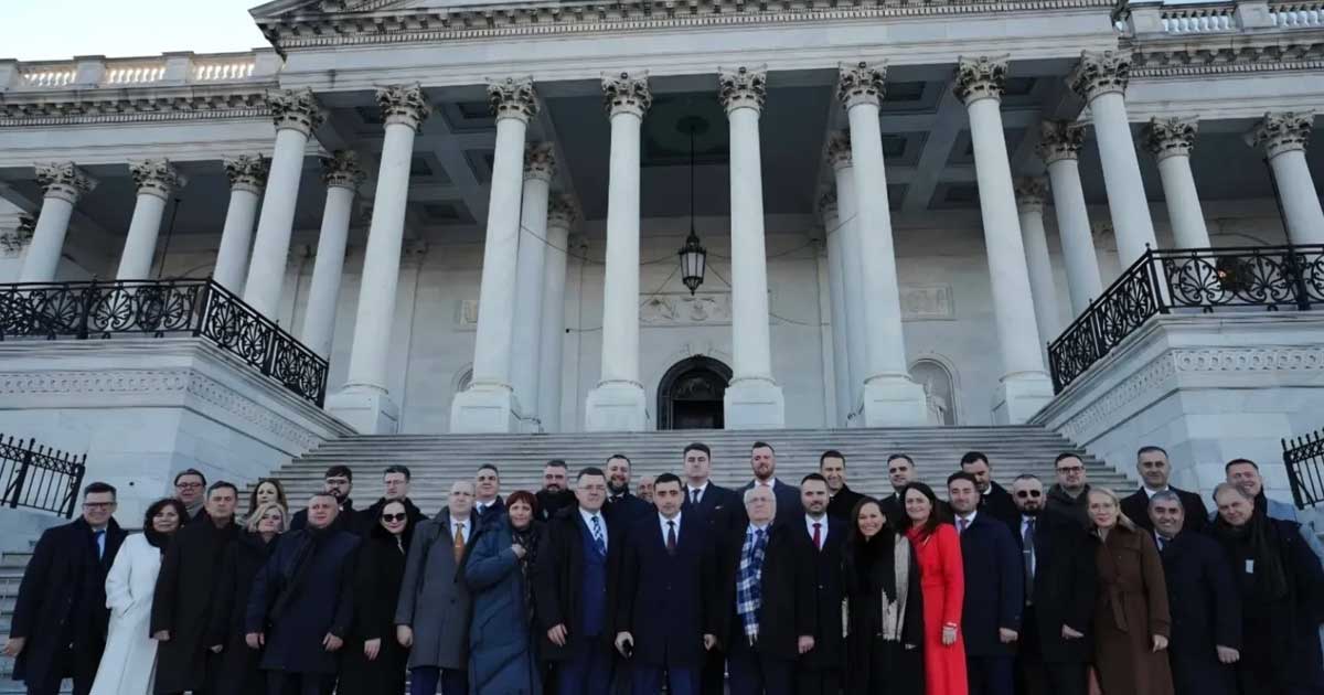 George Simion tăind tortul în forma Groenlandei la recepția de la Trump Kennedy Art Center, Washington, ianuarie 2026