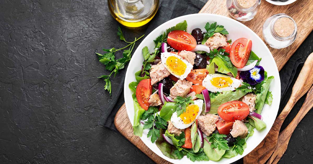 Masă mediteraneană cu fructe, legume proaspete, pește și ulei de măsline, ilustrare pentru beneficiile dietei asupra fumătorilor