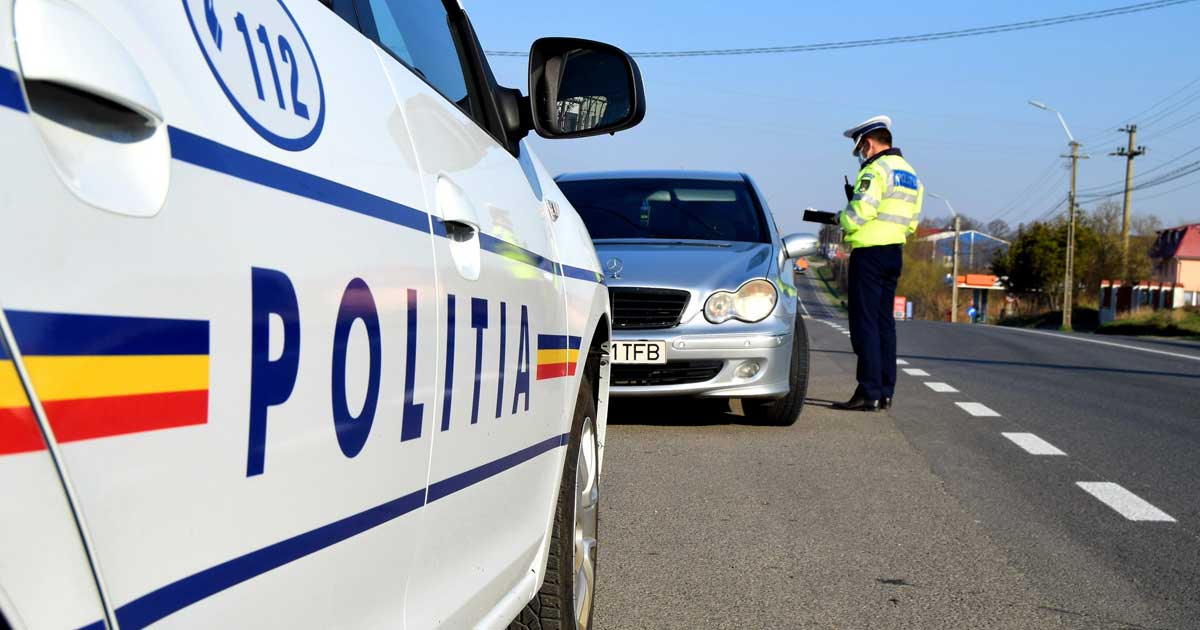 Polițist rutier aplicând o amendă unui șofer pe o stradă din România, vară 2026