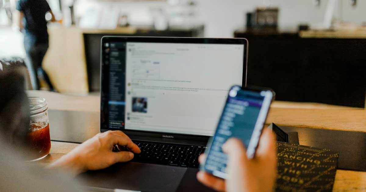 Persoană folosind un laptop și un telefon mobil, simbol al competențelor digitale în România, august 2026