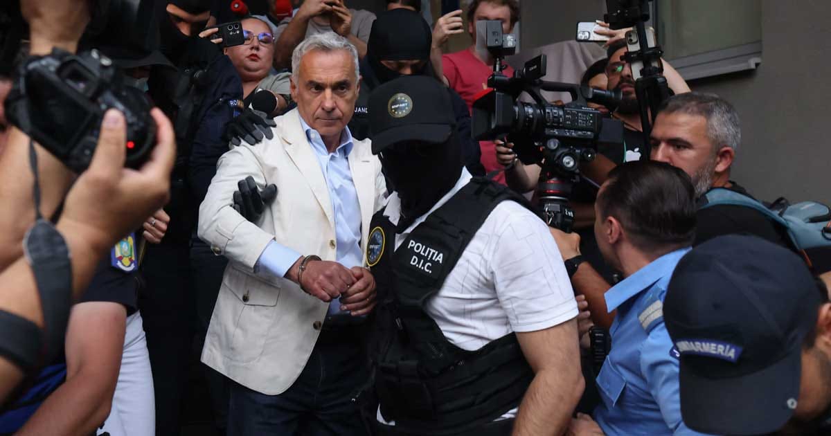Călin Georgescu însoțit de polițiști la sediul Tribunalului București pentru audierea privind arestarea preventivă, septembrie 2026