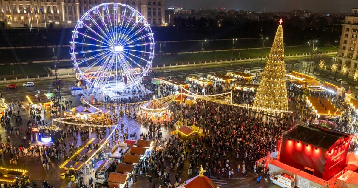 Târgul de Crăciun din Piața Constituției, București, cu bradul luminat, casuțe din lemn și vizitatori pe alei